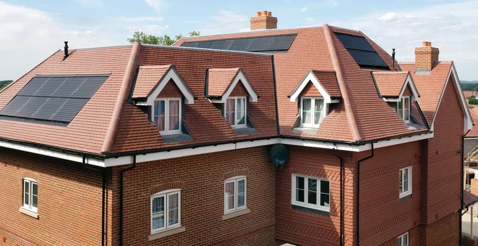 Manufacturer example roof with Sandtoft Rustic concrete plain tiles, dormers and roof-integrated solar panels